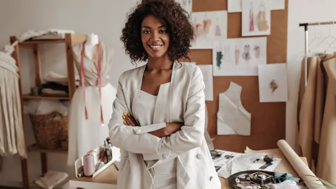 Empreendedorismo: uma mulher no centro da imagem posando para foto em um escritório.