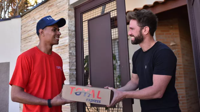 Logística para e-commerce: um entregador deixa a encomenda com o cliente na porta de sua casa.
