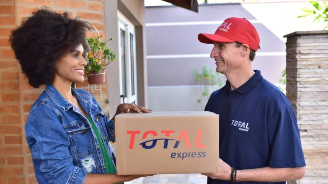 Logística reversa: entregador da Total Express recebe caixa da cliente.