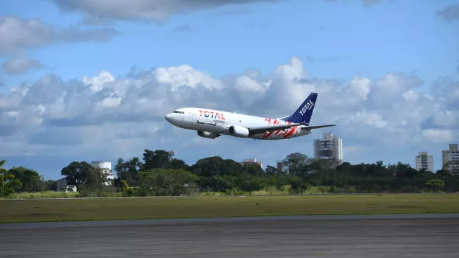 Cross border: Avião com logo da Total Express decolando.