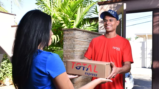 Entregador realiza a entrega de um pacote no mesmo dia, destacando a eficiência do same day delivery para atender às necessidades do cliente com rapidez.