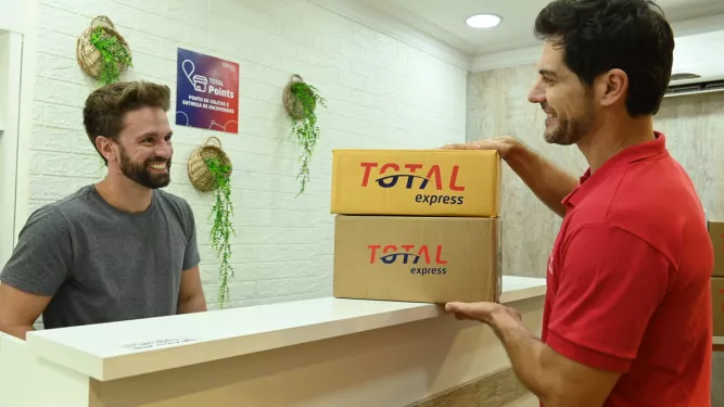 Cliente retirando encomenda em um ponto de retirada da Total Express.