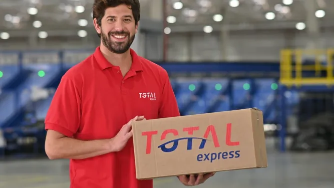 Funcionário segurando embalagem de dimensões médias da Total Express