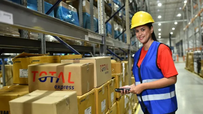 Funcionária realizando picking e packing para uma entrega.