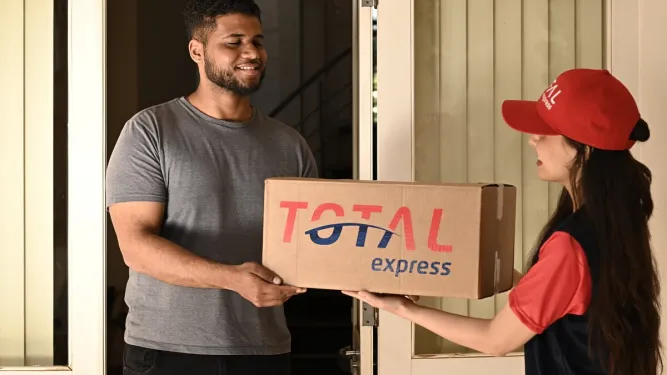 Funcionária da Total Express fazendo uma entrega à domicílio de frete courier a um cliente