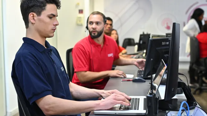 Funcionário utiliza computador para fazer a classificação fiscal de documentos.