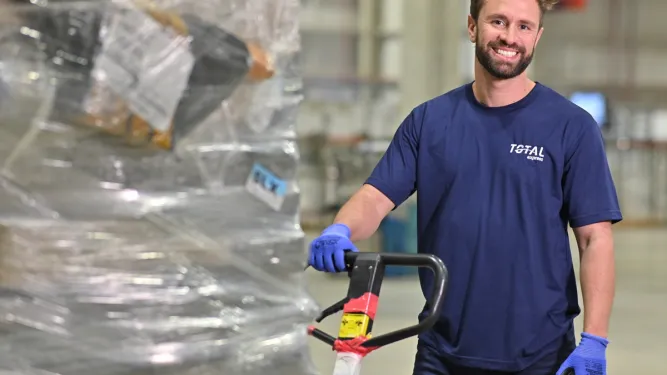 profissional da Total Express manuseia uma carga para frete internacional
