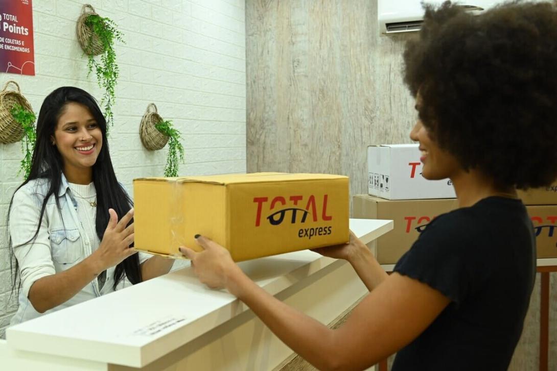 PUDO: Uma atendente entregando a encomenda para uma cliente.