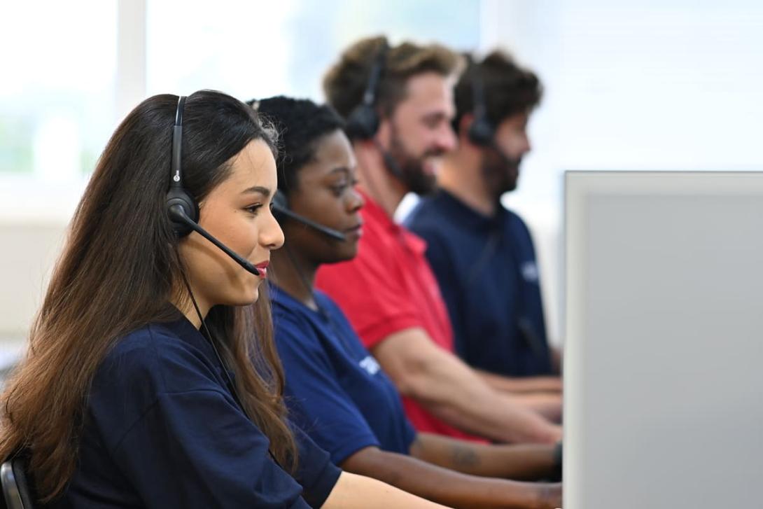 Como melhorar o atendimento ao cliente: na imagem, vemos quatro pessoas lado a lado atendendo clientes por ligação.