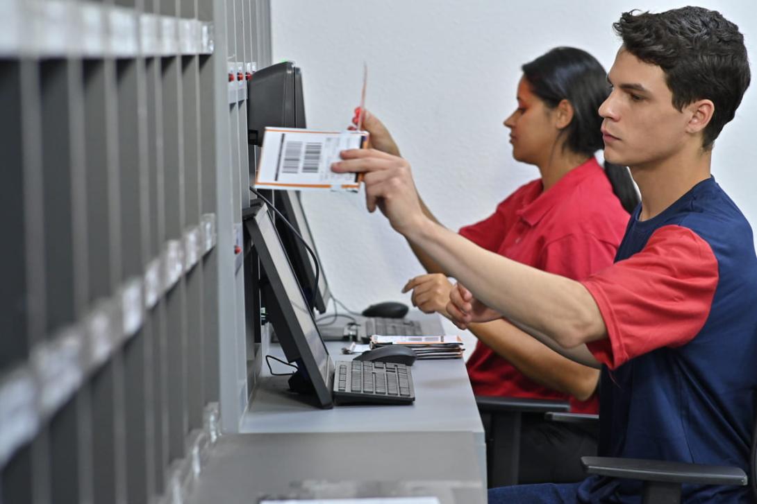 Duas pessoas atendendo o público e realizando entrega de cartões.