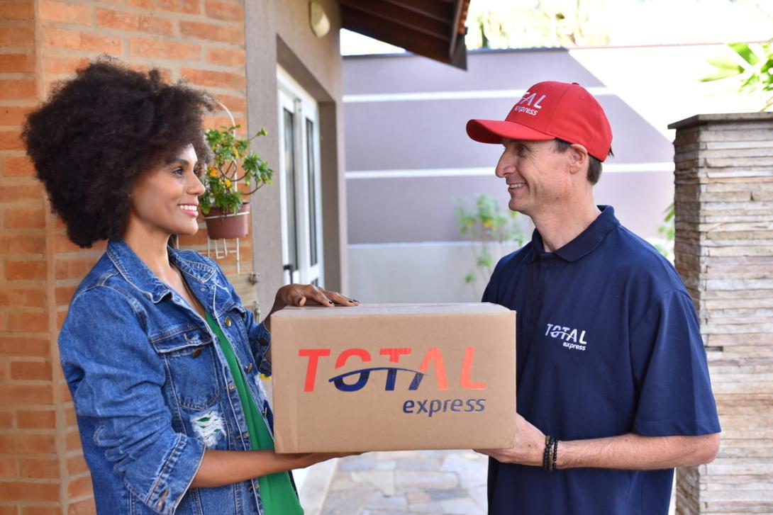 Logística reversa: entregador da Total Express recebe caixa da cliente.