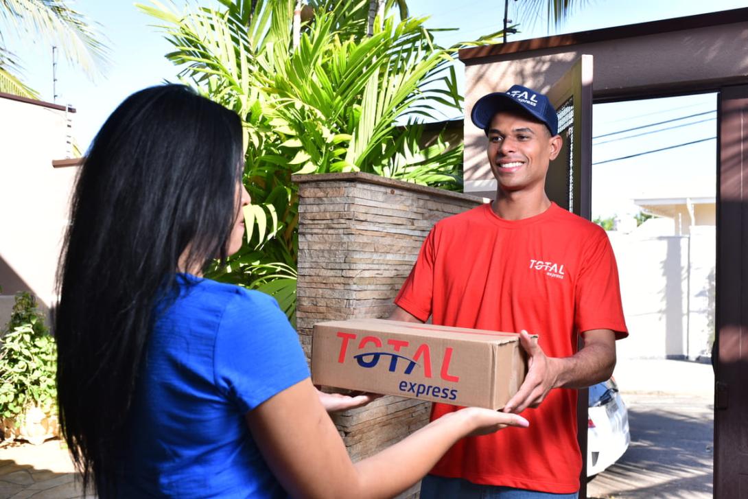 Entregador realiza a entrega de um pacote no mesmo dia, destacando a eficiência do same day delivery para atender às necessidades do cliente com rapidez.