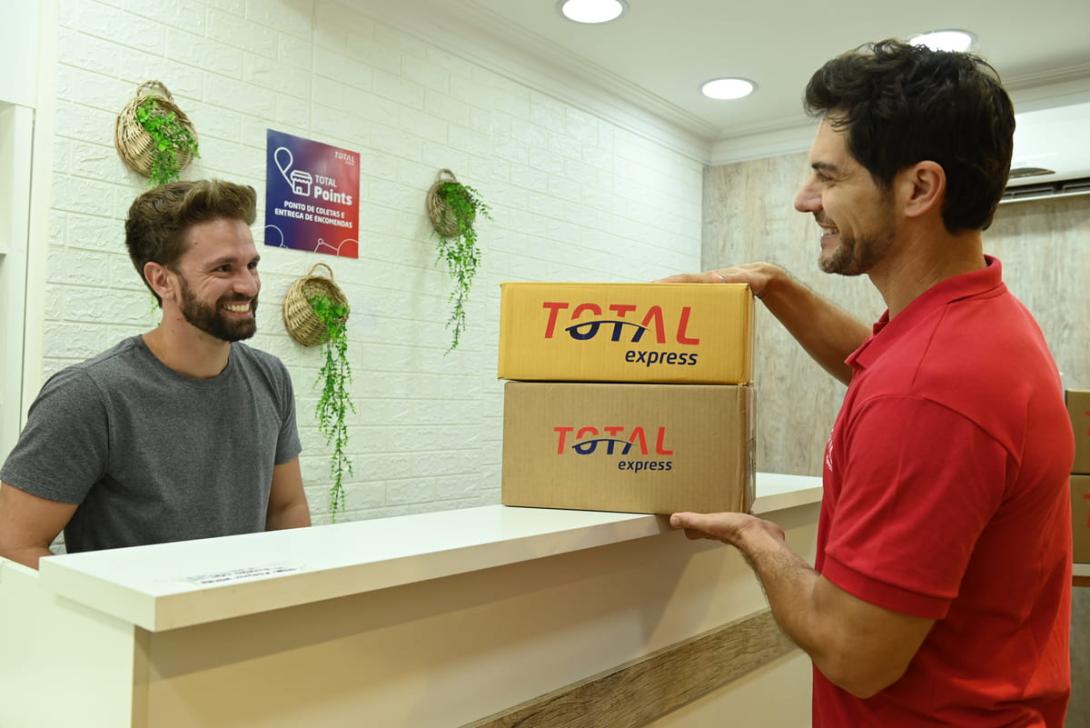 Cliente retirando encomenda em um ponto de retirada da Total Express.
