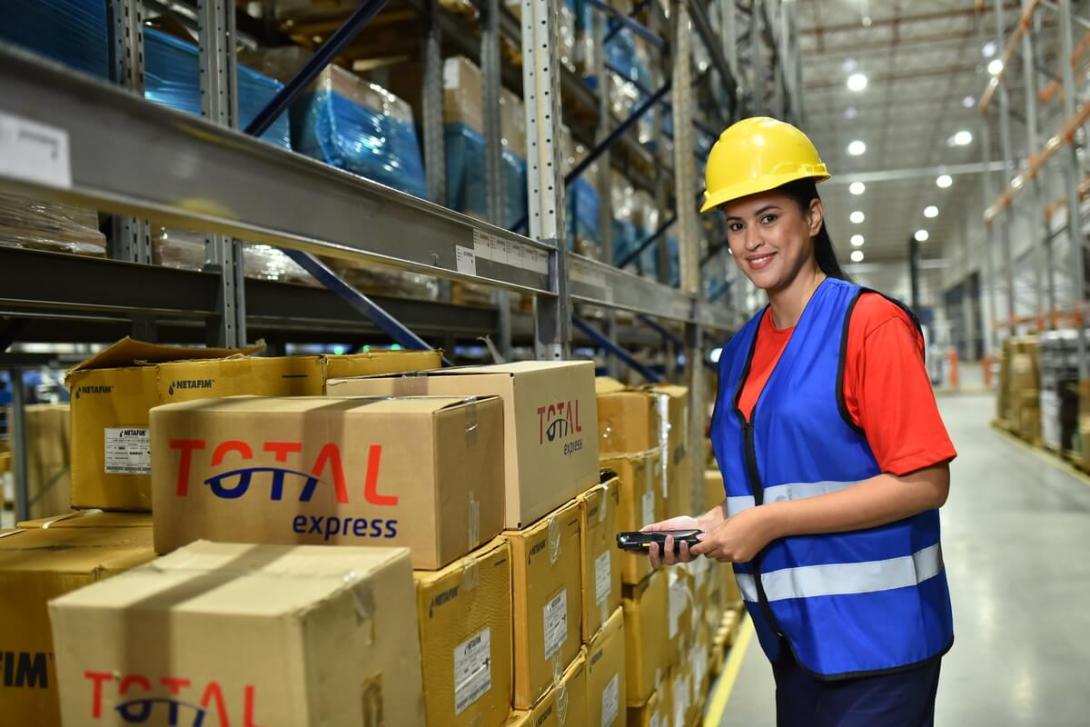 Funcionária realizando picking e packing para uma entrega.