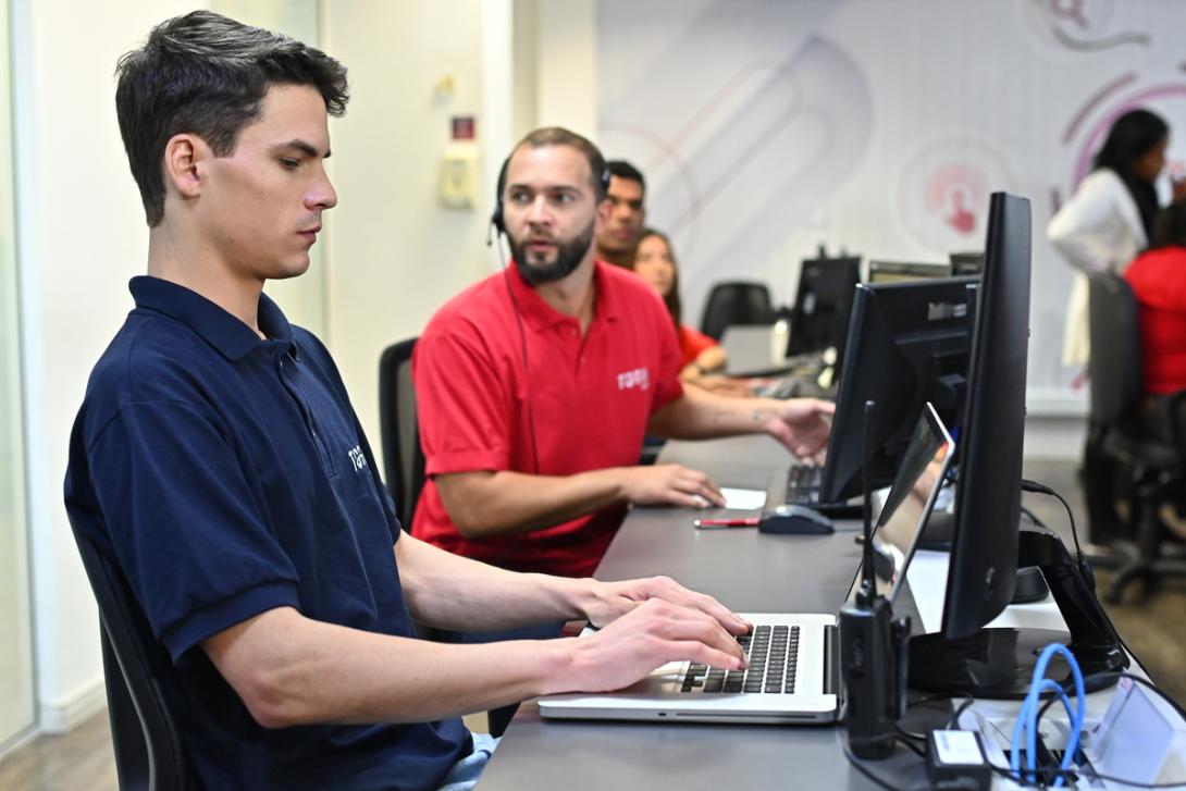 Funcionário utiliza computador para fazer a classificação fiscal de documentos.