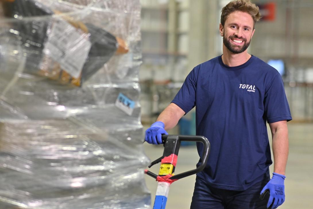 profissional da Total Express manuseia uma carga para frete internacional