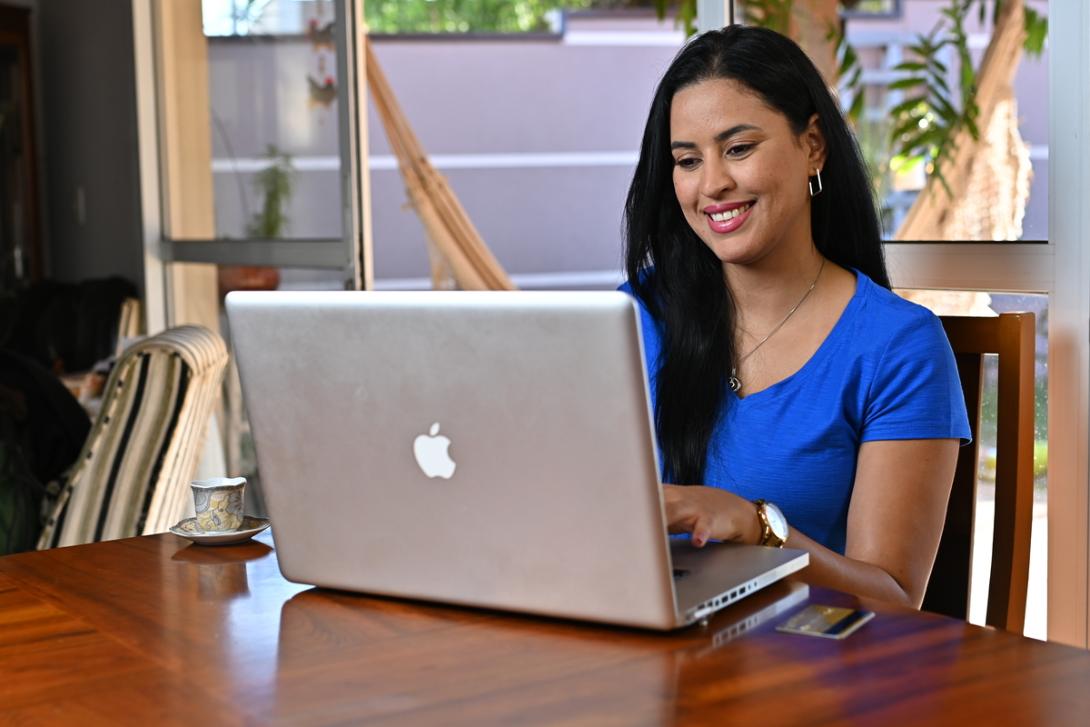 Mulher vestida de azul pesquisa como vender pela internet 