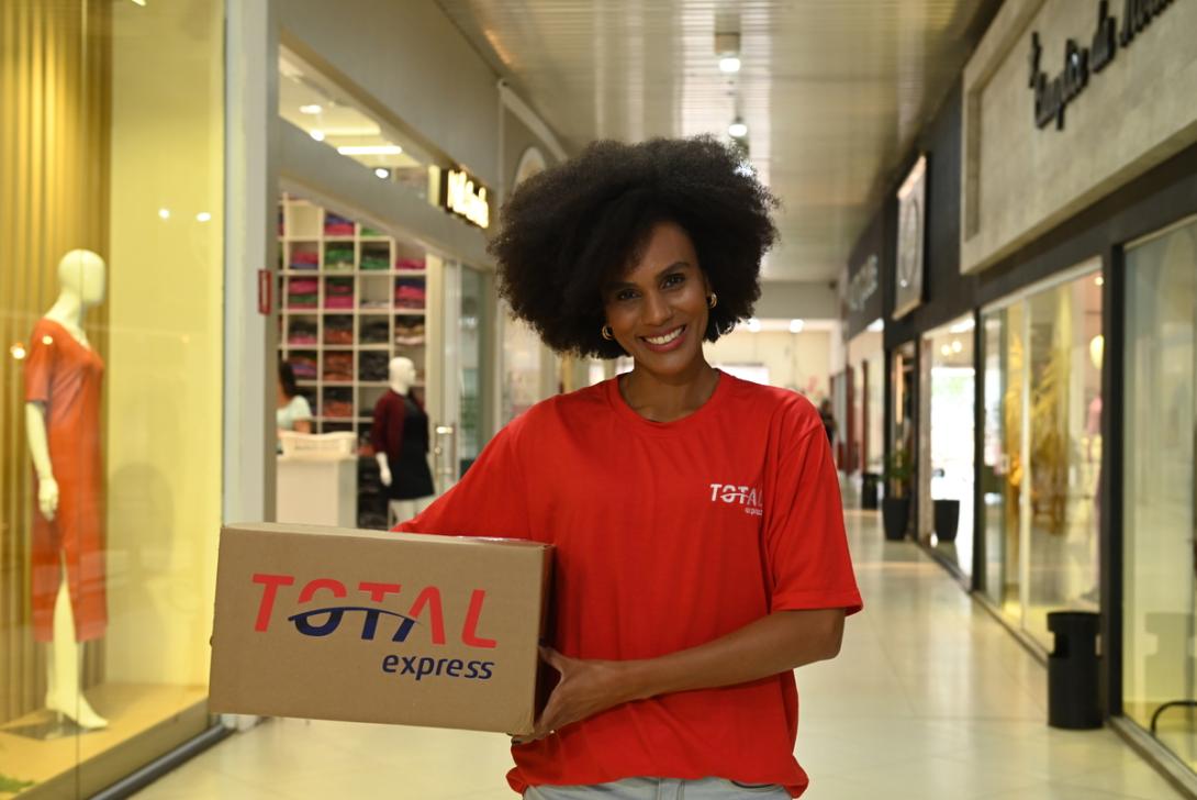 Entregadora segura uma caixa e responde se a Total Express é confiável